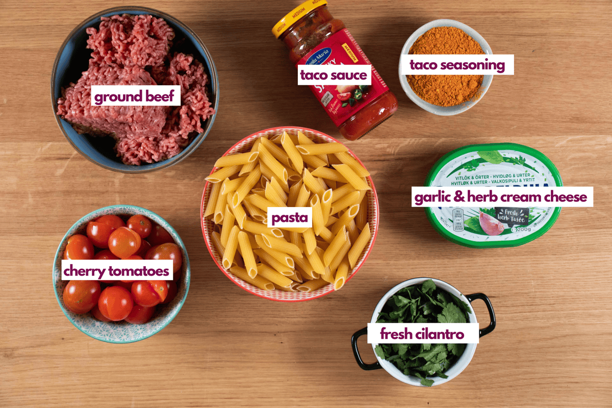 Ingredients for taco pasta including store bought taco sauce, flavored cream cheese, pasta, ground beef and cilantro.