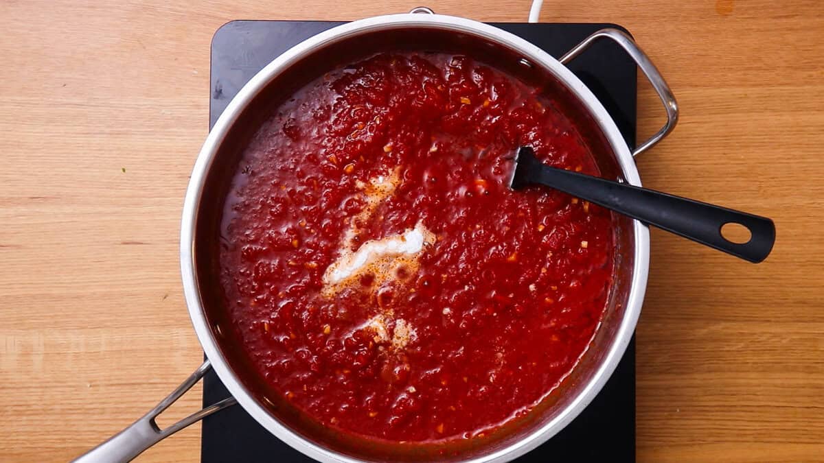 Adding baking powder to make an easy tomato sauce.