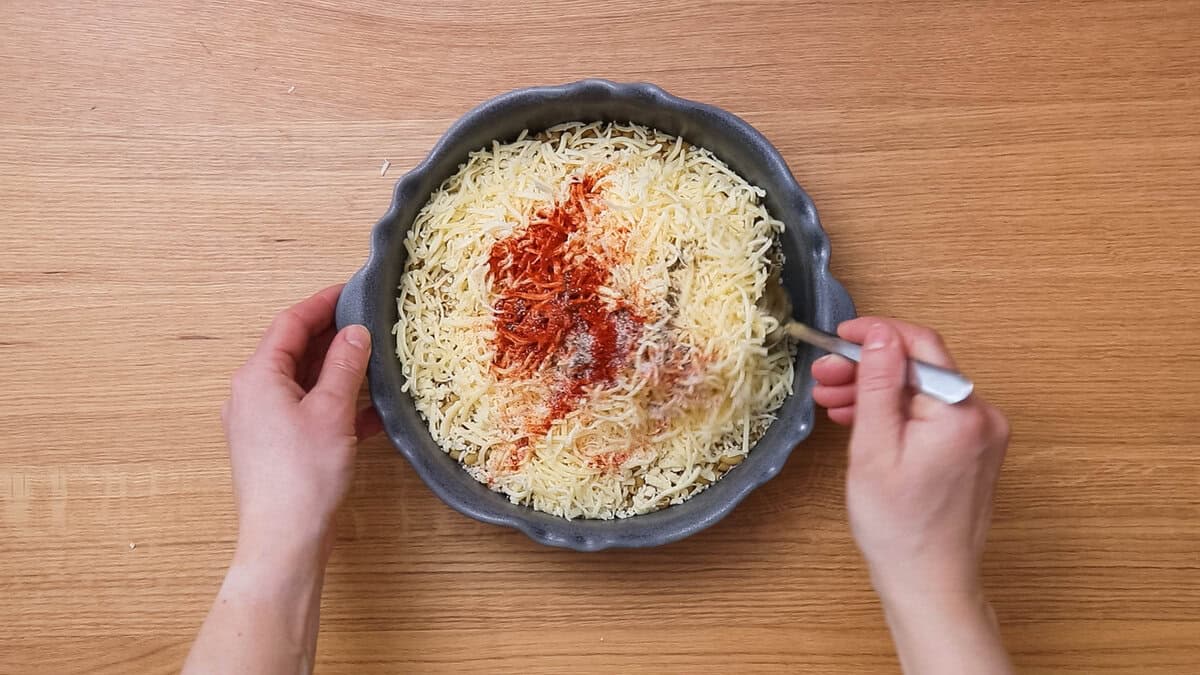 Mixing macaroni, cheese and spices to make gouda mac and cheese.