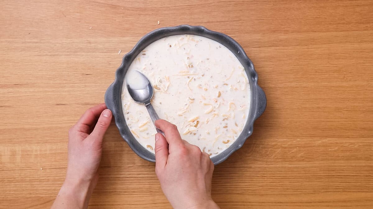 Evening out the surface of a gouda mac and cheese before baking.