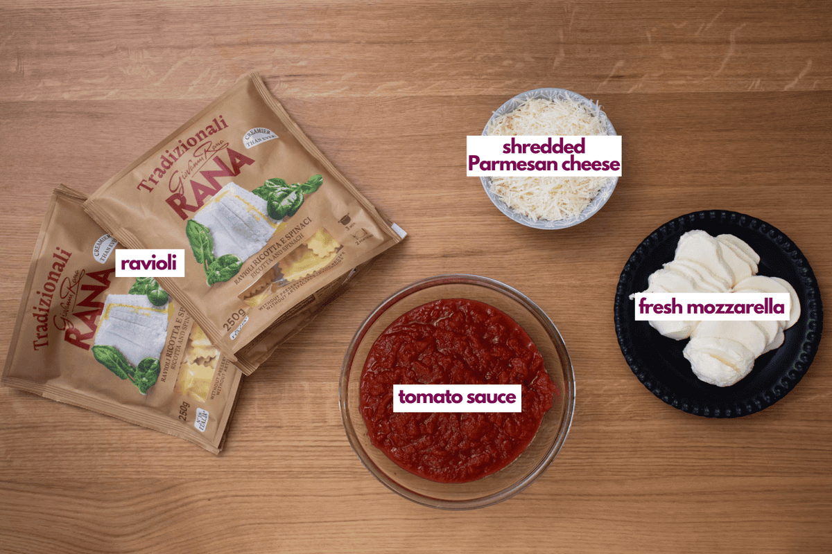 Ingredients needed to make a lazy lasagna including ravioli, tomato sauce, shredded parmesan cheese and fresh mozzarella cheese.