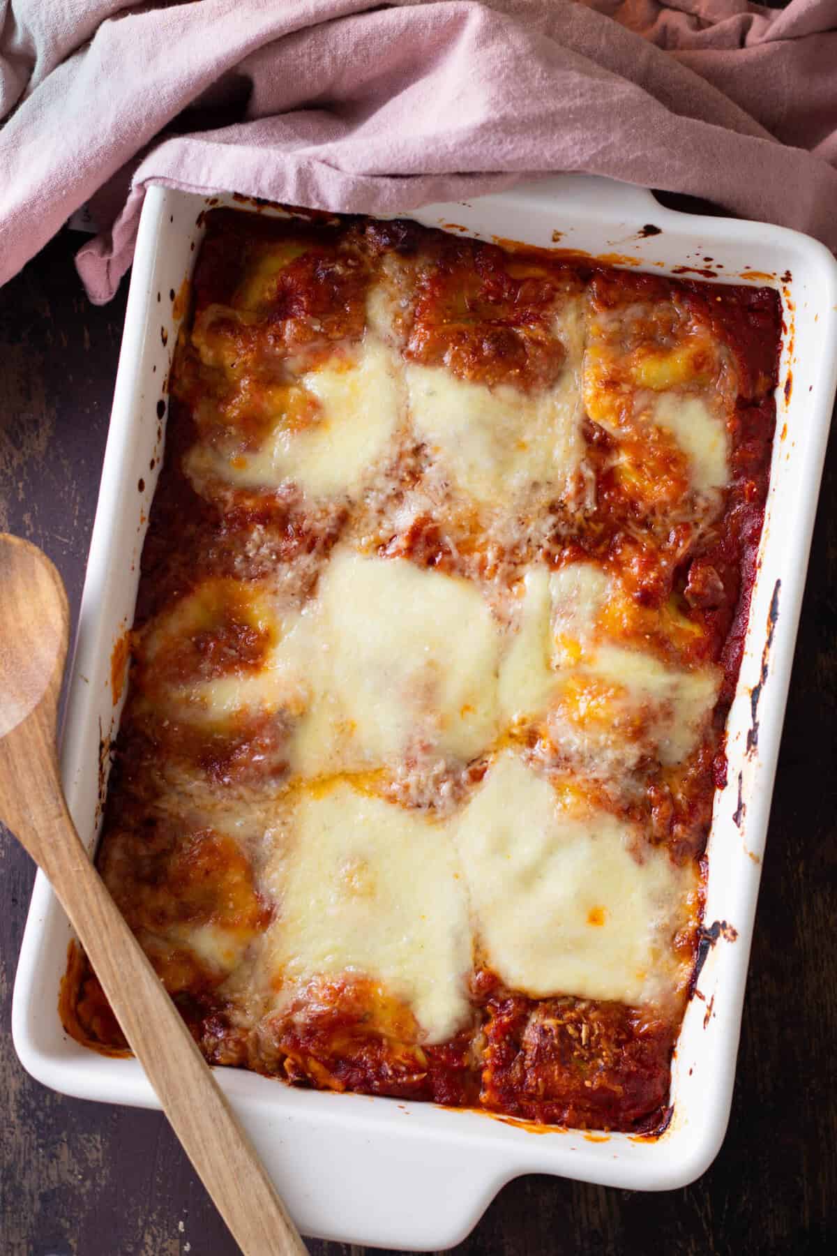 Top down view of a lazy lasagna with ravioli and tomato sauce and lots of cheese.