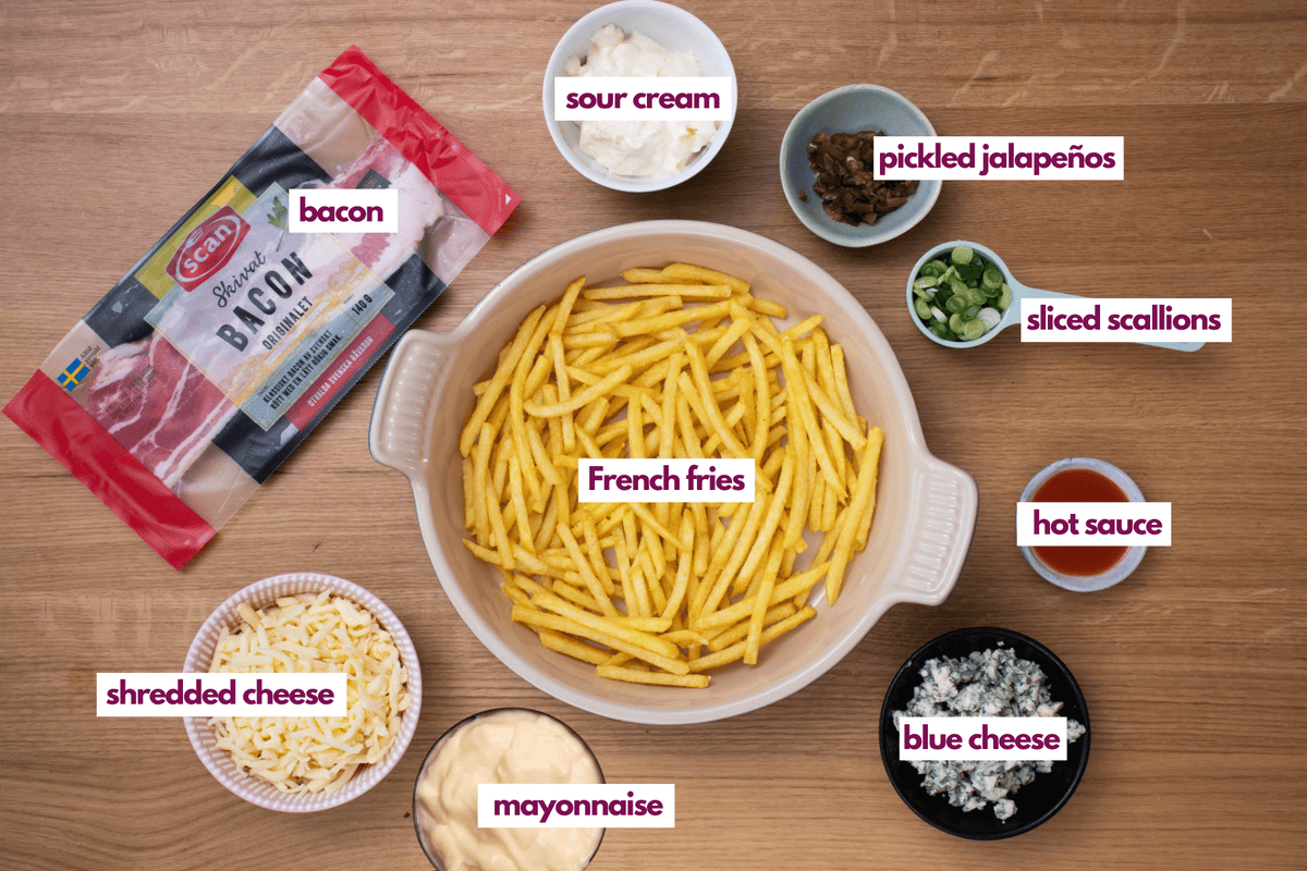 ingredients needed to make buffalo fries including french fries, bacon, sour cream, blue cheese and hot sauce.