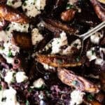 Close up of potato wedges topped with feta cheese and black olives.