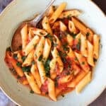 A bowl with penne pomodoro (pasta with basil tomato sauce).