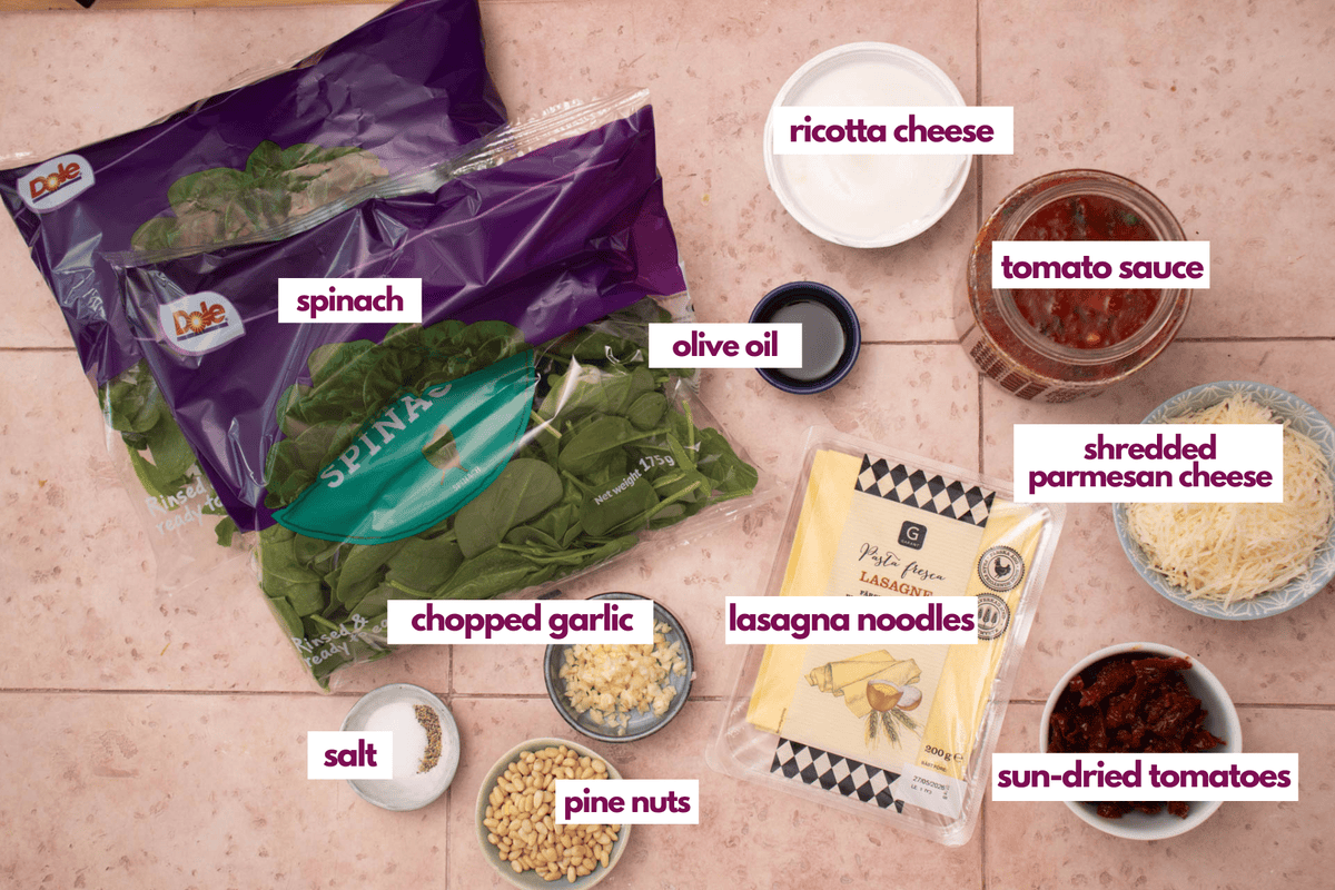 Ingredients for spinach lasagna including ricotta, parmesan, pine nuts and sun-dried tomatoes.